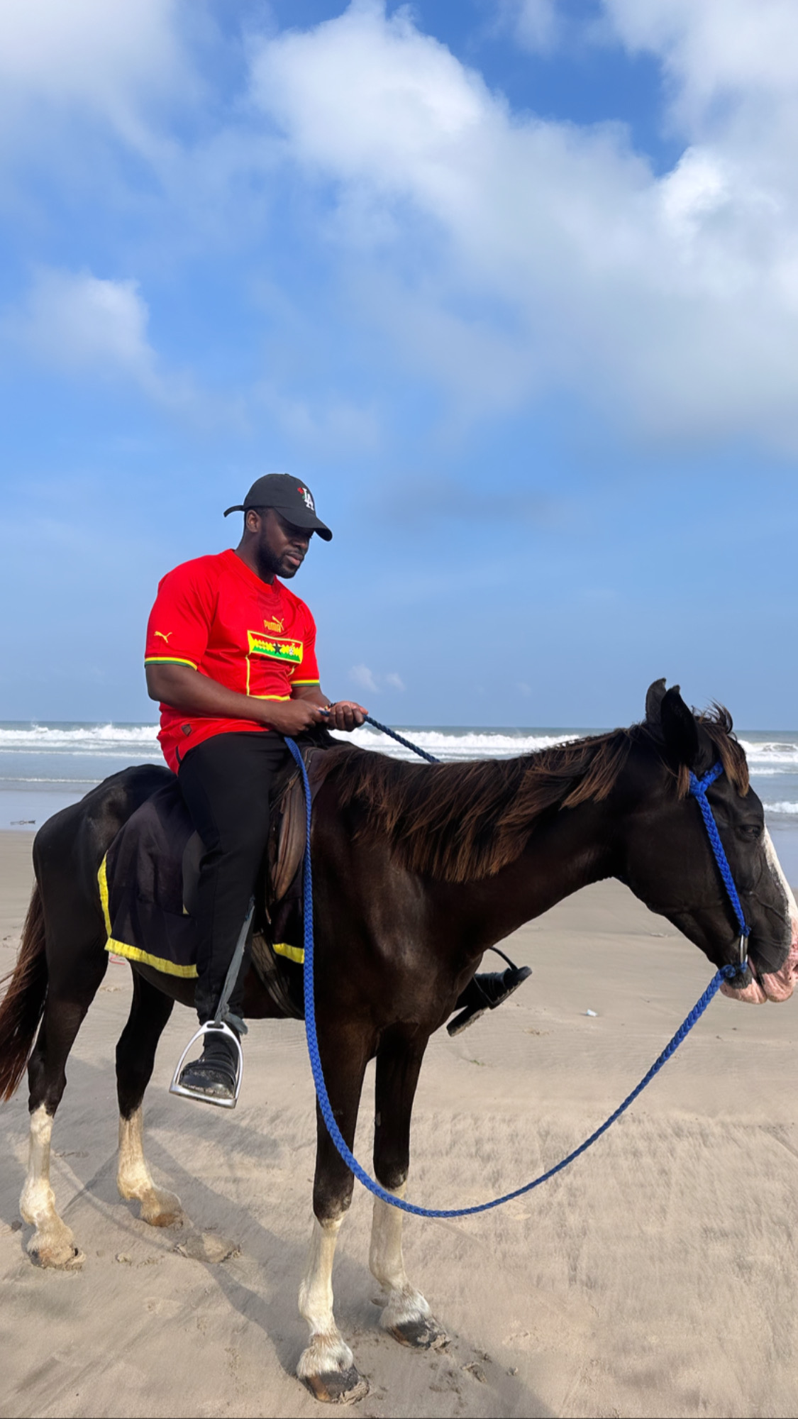 Koby riding a horse on a beach in Accra, Ghana